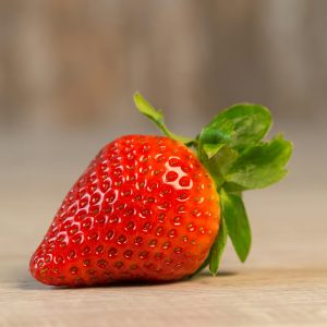A vibrant close-up of a single, ripe strawberry showcasing freshness and vivid color.
